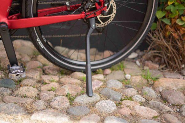 A closeup at a kickstand on a red bike