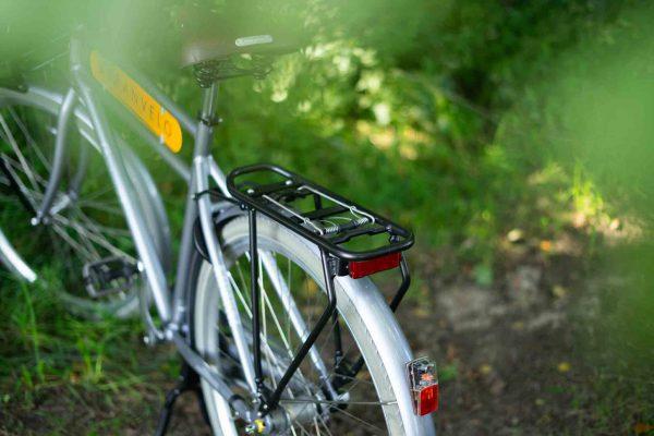 A black rack on a trail with greenery all around.