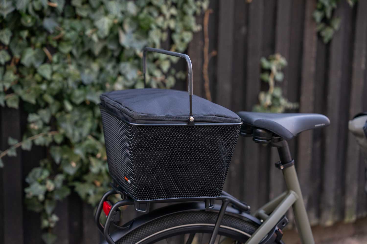 A basket with an infill, in the background you can see some greens and a black fence