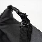 Closeup on handles and buckles on a grey bag with light grey background in studio