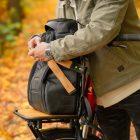 A man in a yellow autumn forest with his bicycle infront of him