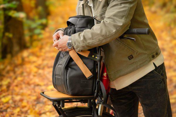 A man in a yellow autumn forest with his bicycle infront of him