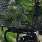A mesh basket on a front carrier. In the background you can see grass.