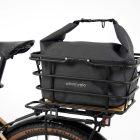 Grey bag with light grey background in studio in a basket on a bike