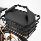 Grey bag with light grey background in studio in a basket on a bike