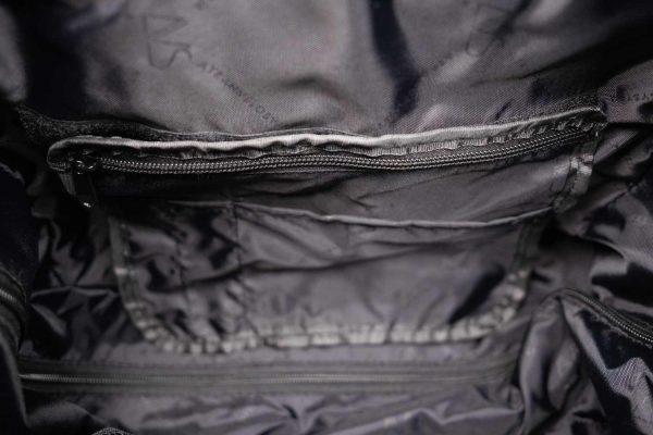 Inside of travel tog bag. Its is black interior meh and it has one zippered pocket, one open pocket and two penholders.