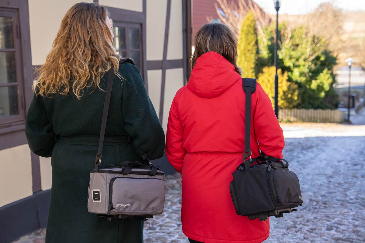 Two women walking down the street with one shoulderbag each