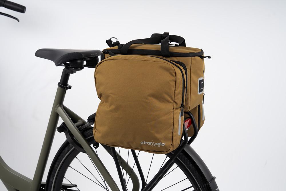 A picture of a brown bag on a rear carrier on a bicycle in a studio