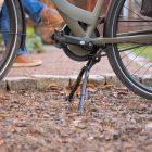 A double kickstand out in nature on abicycle, in the back you can see two feet