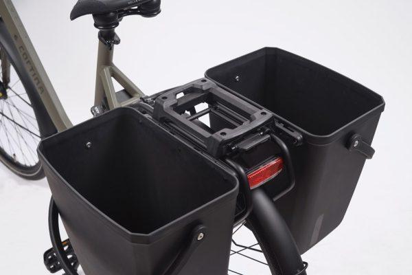 Two black baskets on the side of a rear carrier in a studio