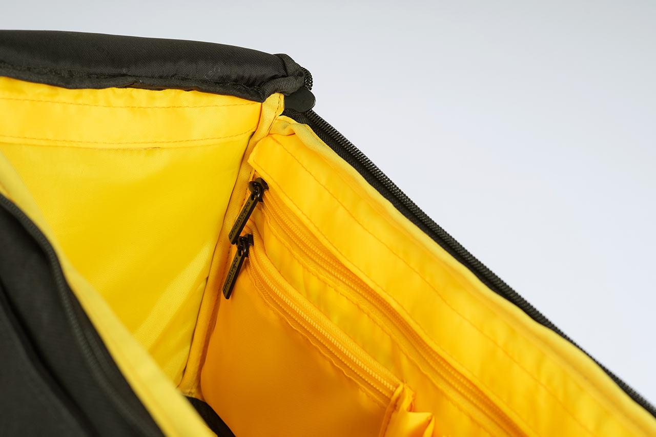 A black topbag in a studio, a yellow inside