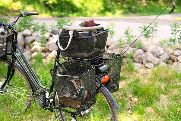 three baskets on a bike out in nature, two at the sides and one at the top