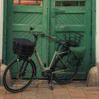 A green bike, green sidebag and a green door