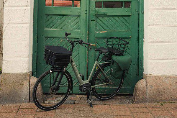 A green bike, green sidebag and a green door