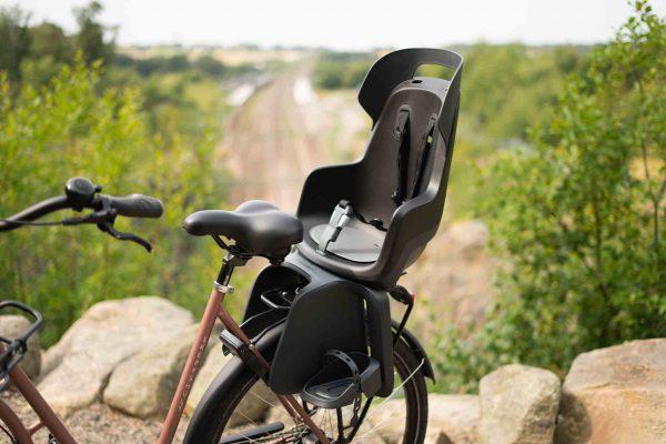 A bicycle with a carrier and a black childseat