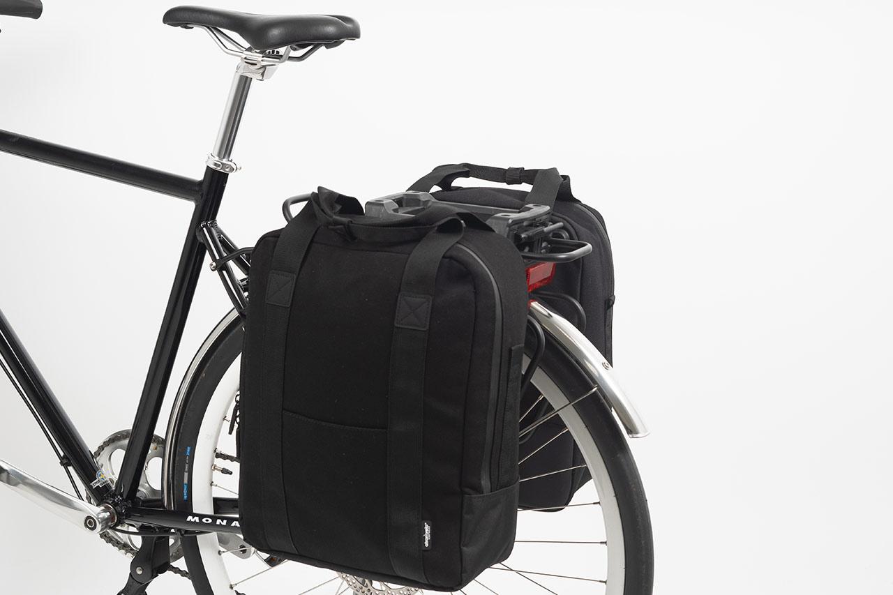 Two black sidebags in a studio on a bike