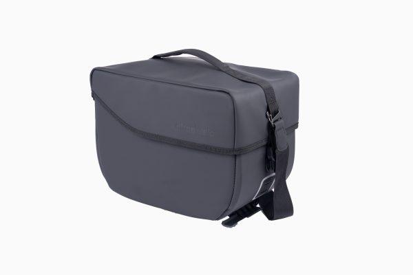 A studiopicture at a grey topbag from the side