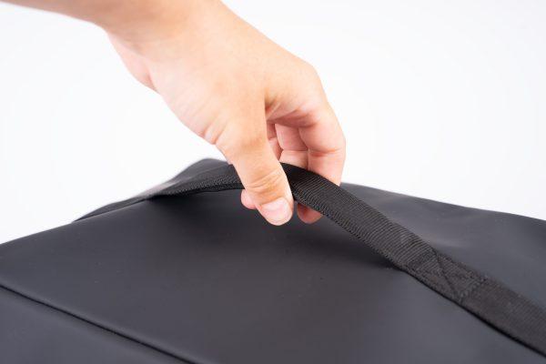 closeup at a grey top bag at the handle