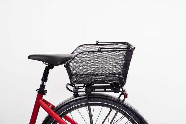 Black net basket in a studio on a red bicycle