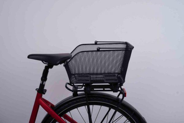 Black net basket on a red bike in a studio