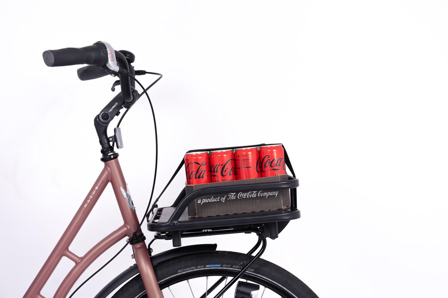 A black crate on a front carrier in a studio with a tray of soda on it