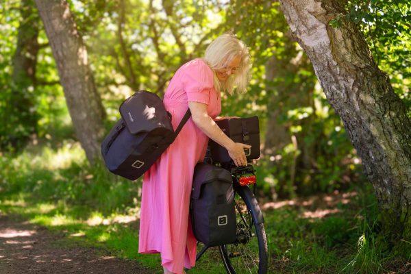 Woman in pink dress lifts off a commuter top wp outside