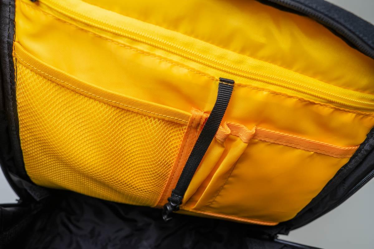 A yellow inside of a black bag with multiple compartments